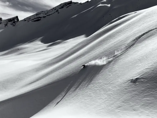 Andrea Murisasco traccia una curva in neve fresca su un pendio aperto